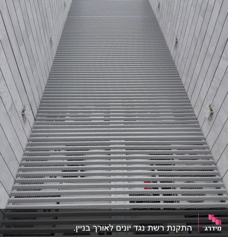 רשת מתכת מותקנת על קיר למניעת כניסת יונים